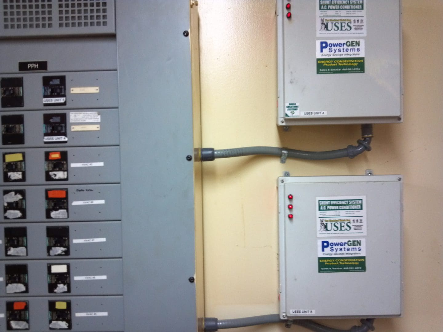 Two electricity meters mounted on a wall with cables and a mailbox unit beside them.