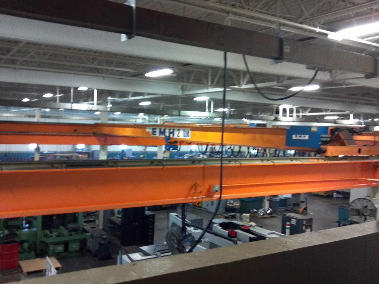 Industrial crane lifting materials in a factory setting.