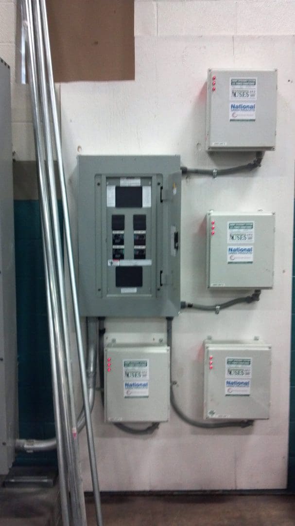 Electrical panels and control boxes mounted on a wall in an industrial setting.