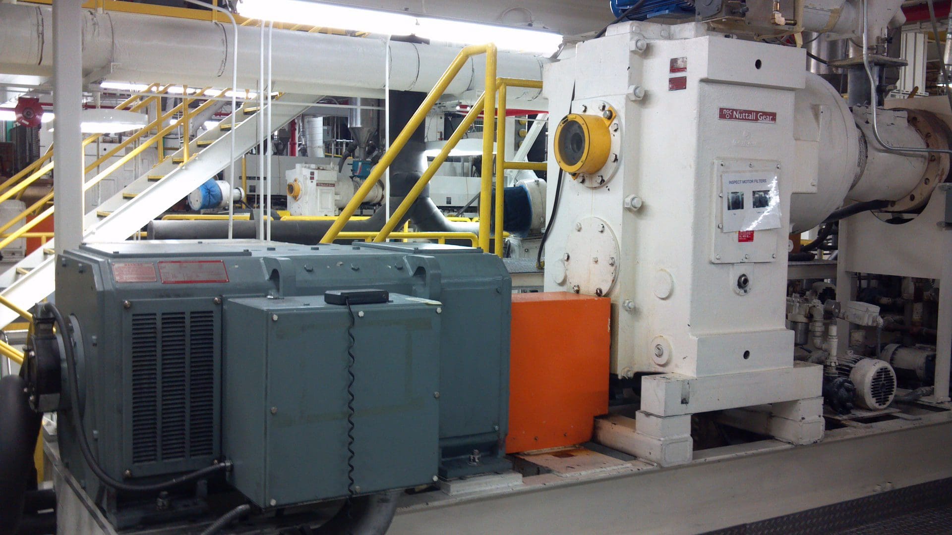 Industrial machinery with yellow railings and large electrical components.