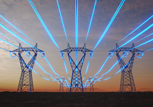 Steel transmission towers stretch across a desert plain at sunset while glowing blue strands symbolize data-intensive artificial intelligence increasing power consumption.